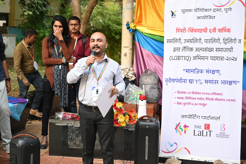 Pride organizers on the dias with a backdrop of pride flag
