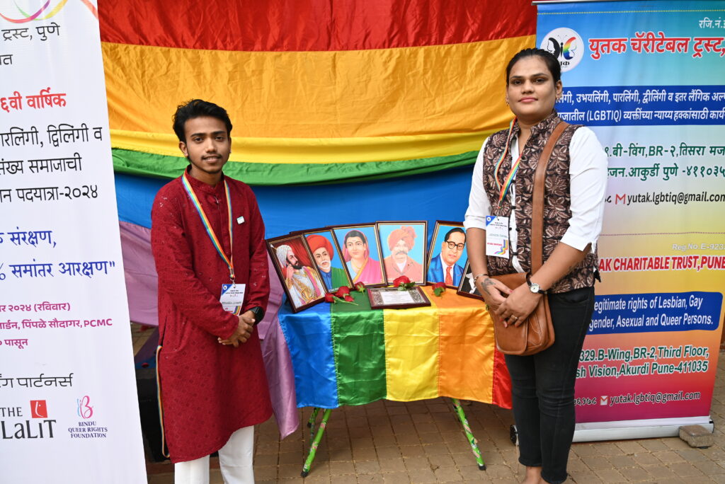 Grand marshals with photo frames of historic leaders with a backdrop of pride flag