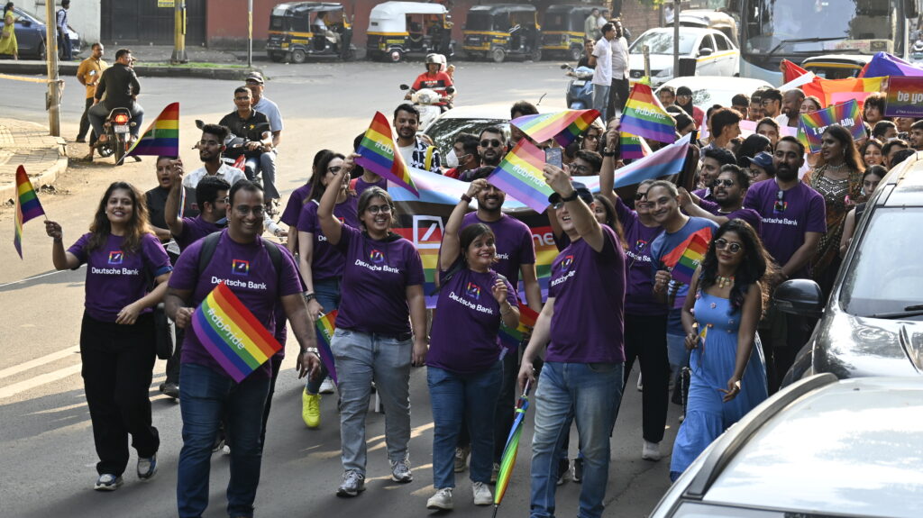 Group of people in purple tshirts of 'Deutsche Bank' showing corporate support in Pride Walk
